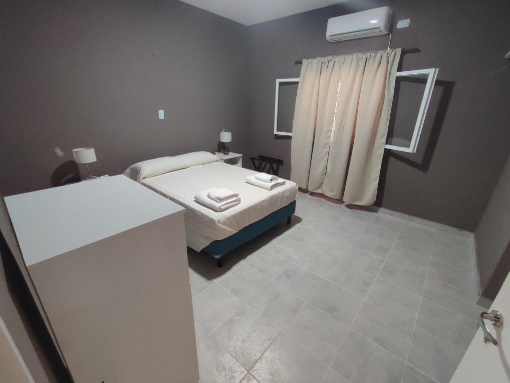 um pequeno quarto com uma cama e uma casa de banho em Hosteria de Anquincila em Anquincila