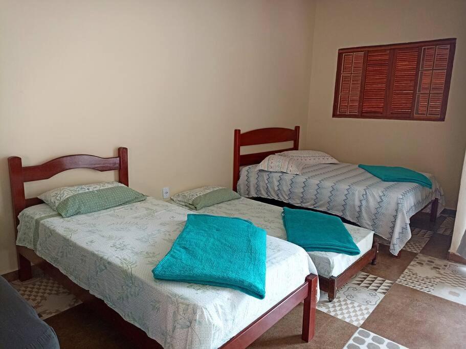 2 łóżka w pokoju z niebieskimi poduszkami w obiekcie Amplo Loft integrado com vista para montanhas! w mieście Itanhandu