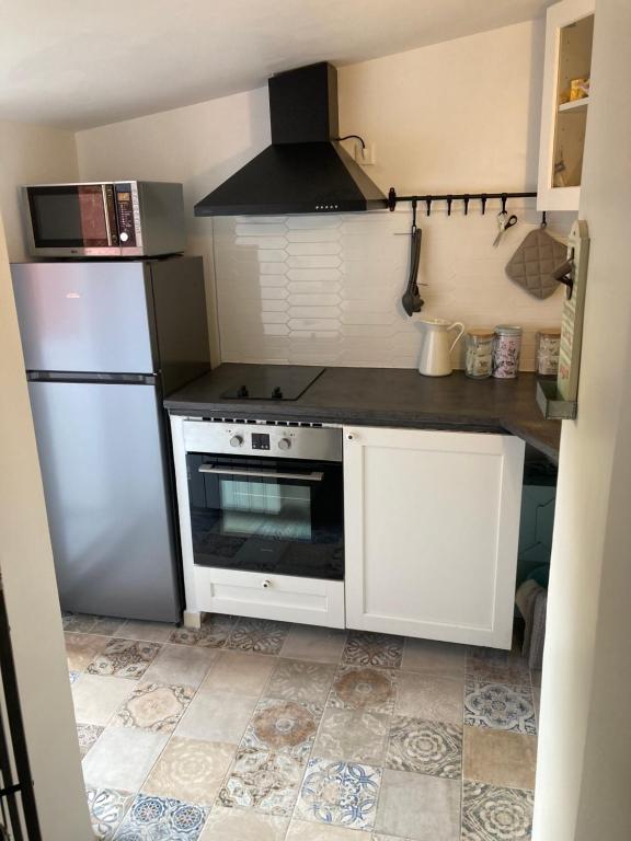 a kitchen with a white refrigerator and a stove at Cosy nest from 10 minutes PARIS centre in Saint-Ouen