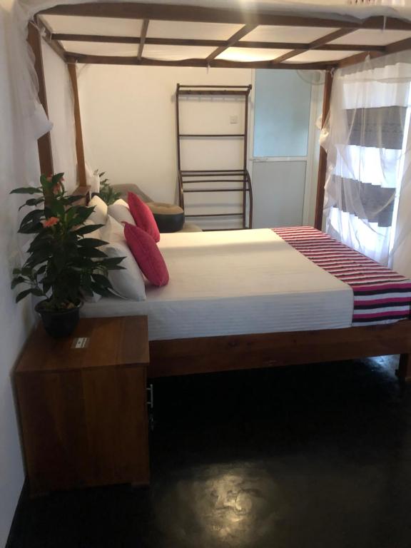 迪克韋勒的住宿－Hiriketiya New Radiant House，一间卧室,床上有植物