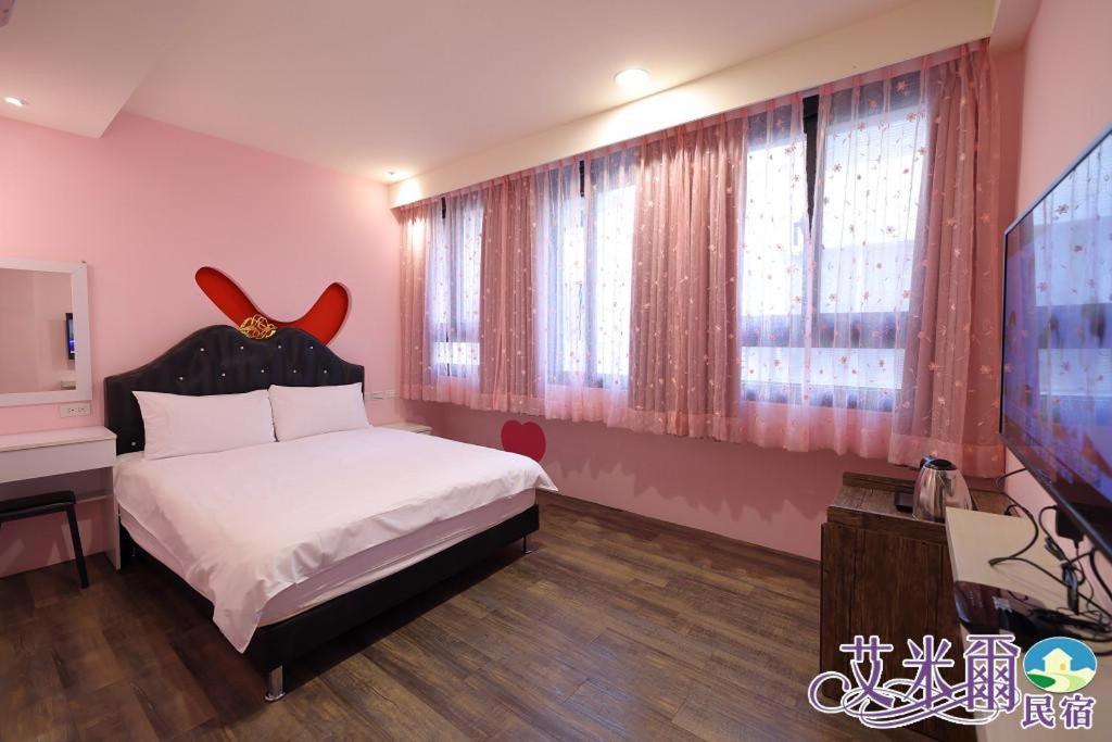 a bedroom with a bed and a flat screen tv at Amir B&B train station & elevator with parking lot in Hualien City