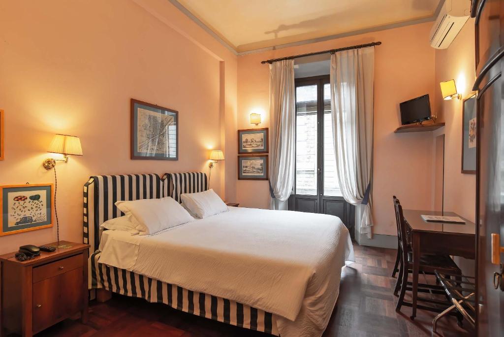 a bedroom with a bed and a desk and a window at Residenza Johanna I in Florence