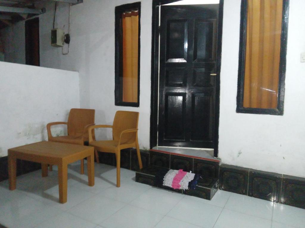 a room with two chairs and a table and a door at Tui Homestay in Plambi