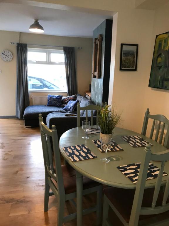 a living room with a table and a couch at Cosy 3 bedroom house close to beach in Lowestoft