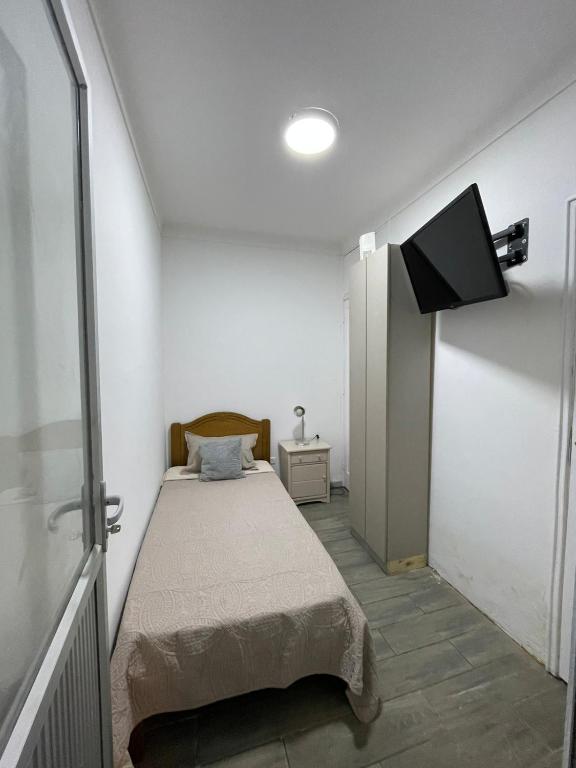 een slaapkamer met een bed en een flatscreen-tv bij Habitación pleno centro de Viña del Mar con entrada y baño independiente privado. r in Viña del Mar