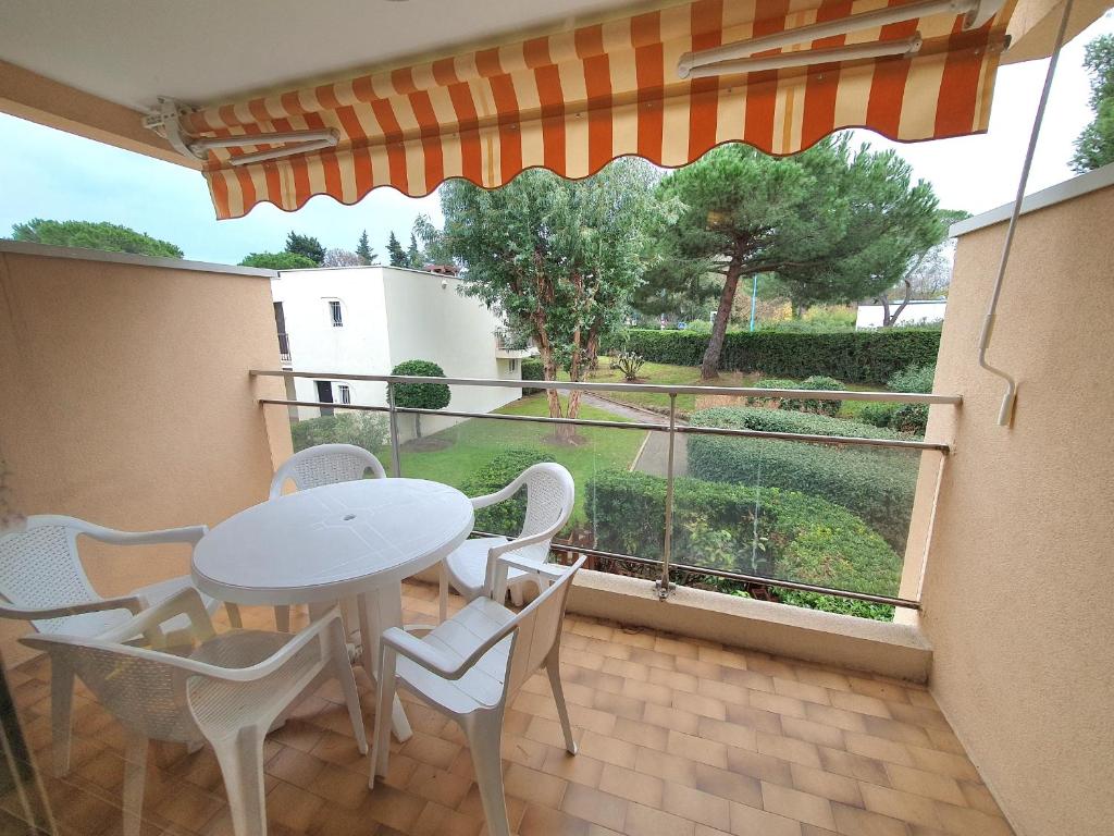 a balcony with a table and chairs and a window at L'OREE DU GOLF in Mandelieu-la-Napoule