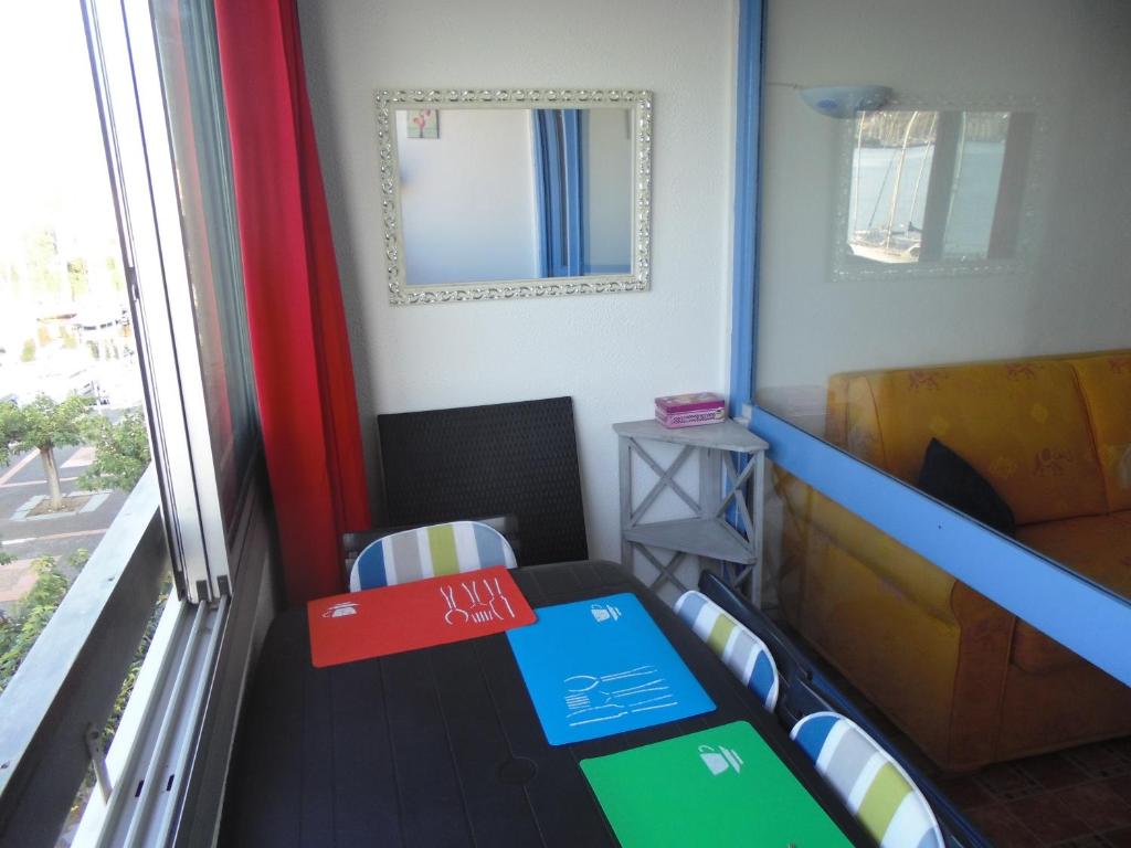 a room with a table and chairs and a window at Vue Mer 180° Parking+Lave-Linge+Proche Plages+Piscine in Cap d&#39;Agde