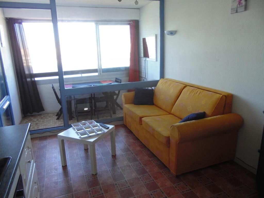 a living room with a couch and a table at Vue Mer 180° Parking+Lave-Linge+Proche Plages+Piscine in Cap d&#39;Agde