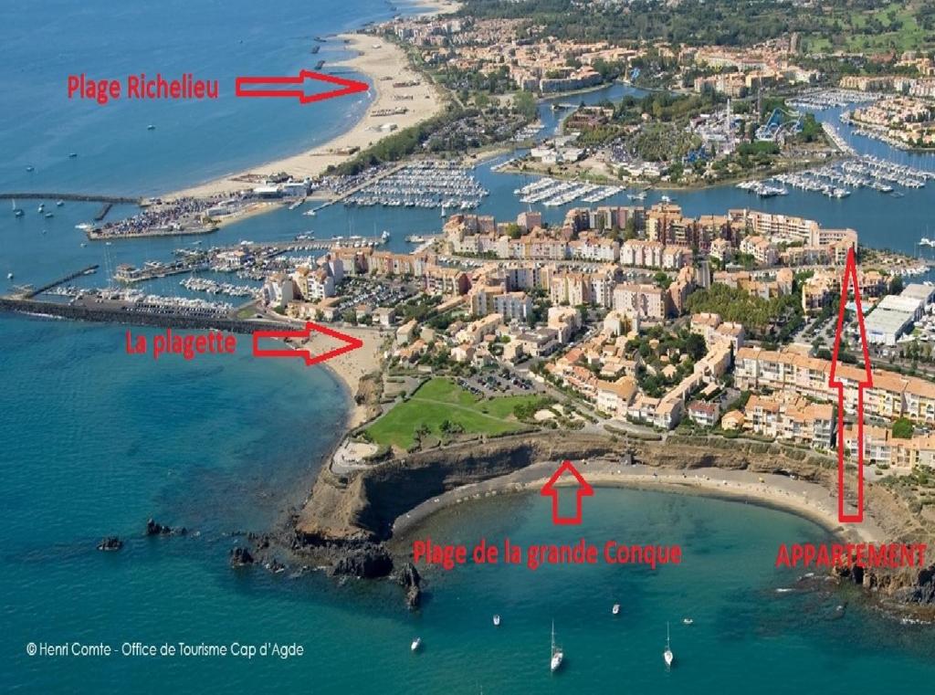 an aerial view of an island with a red arrow pointing to a harbor at Vue Mer 180° Parking+Lave-Linge+Proche Plages+Piscine in Cap d&#39;Agde