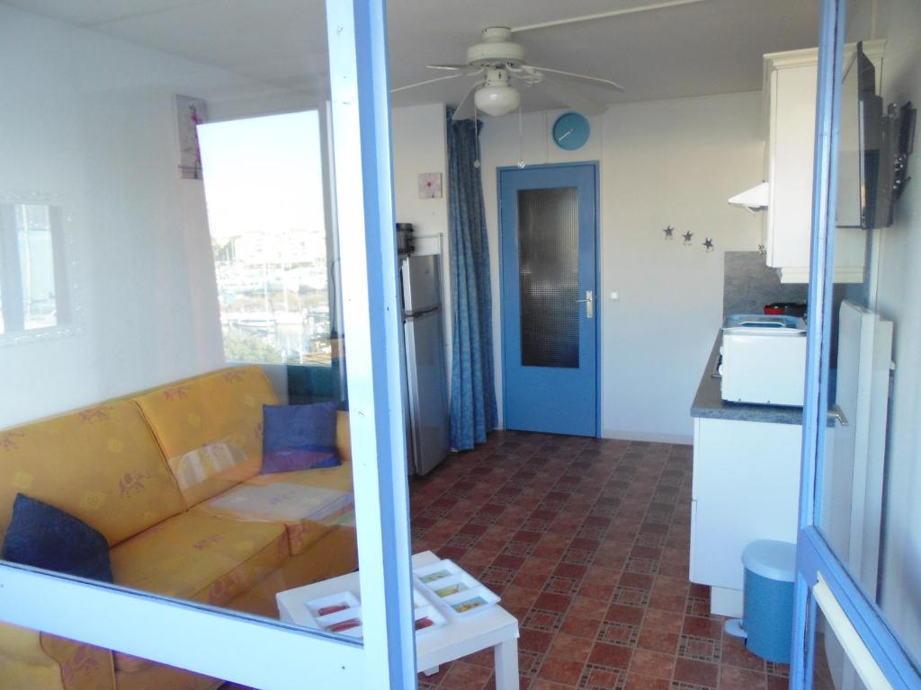 a living room with a couch and a kitchen at Vue Mer 180° Parking+Lave-Linge+Proche Plages+Piscine in Cap d&#39;Agde