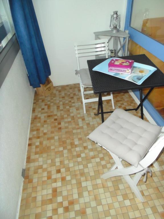 a room with a table and a white chair at Vue Mer 180° Parking+Lave-Linge+Proche Plages+Piscine in Cap d&#39;Agde