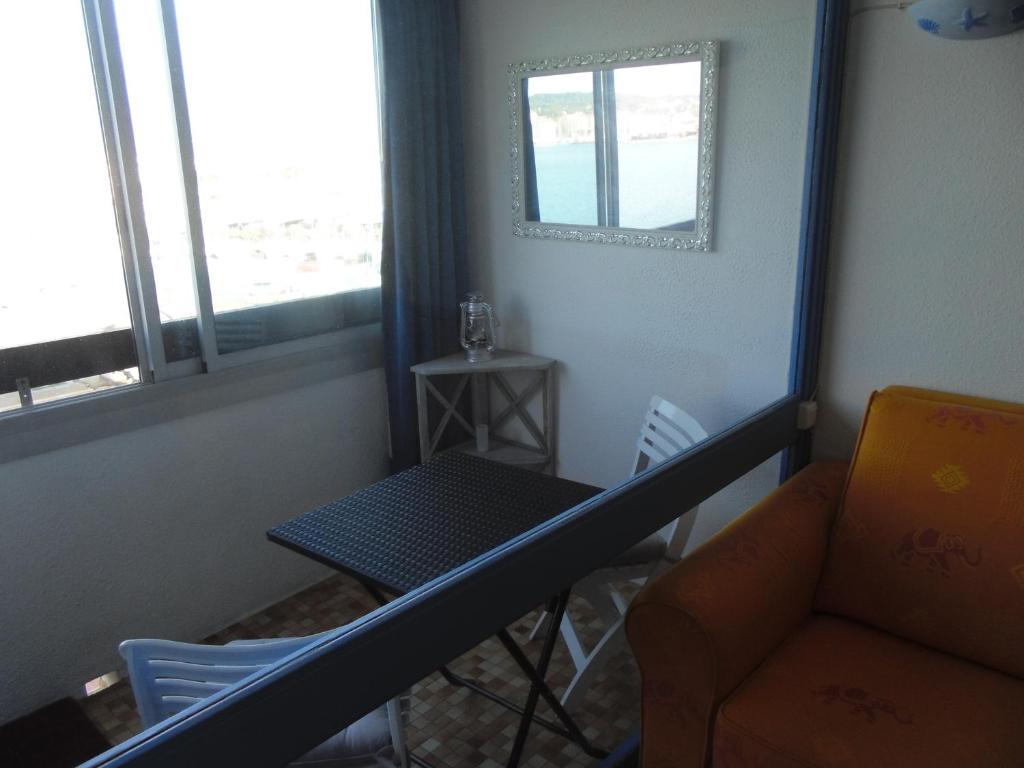 a room with a table and a chair and a mirror at Vue Mer 180° Parking+Lave-Linge+Proche Plages+Piscine in Cap d&#39;Agde
