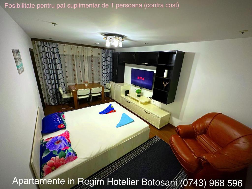 a bedroom with a bed and a chair and a television at Apartament frumos cu 3 camere situat la partier in Botoşani