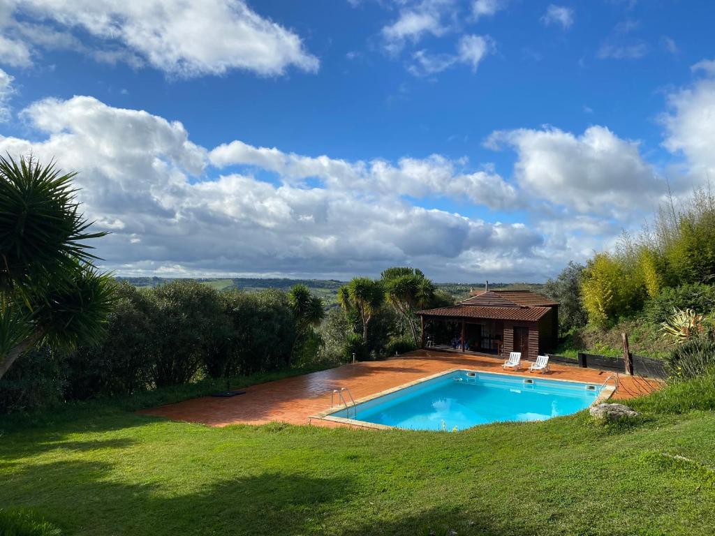 una piscina in un cortile con una casa di Poolside Wooden House a Moçarria