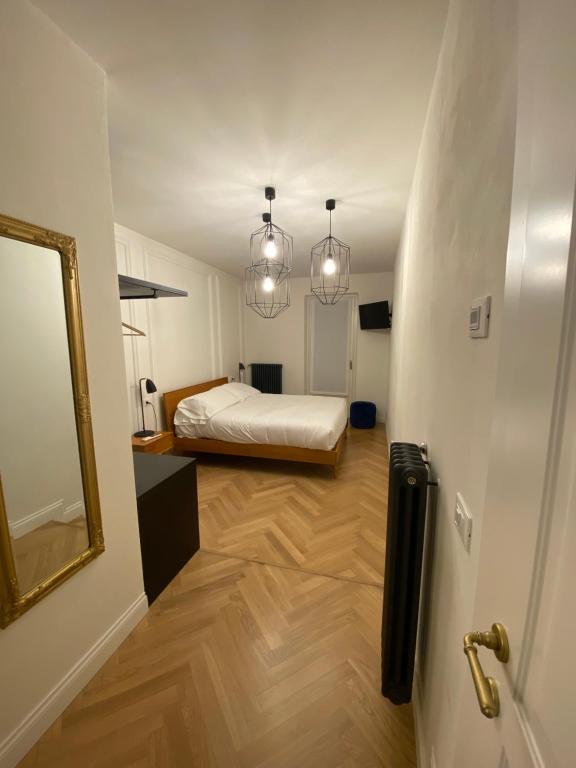 Habitación pequeña con cama y espejo. en Camere La Meridiana, en Domodossola