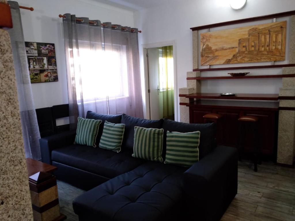 a living room with a blue couch and a piano at Apartamento Balsa in Viseu