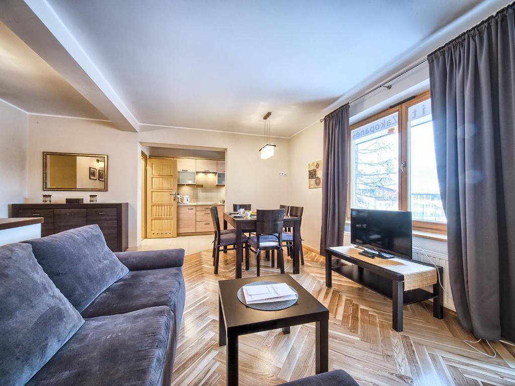 a living room with a couch and a table at VisitZakopane - Lemon Apartment in Zakopane