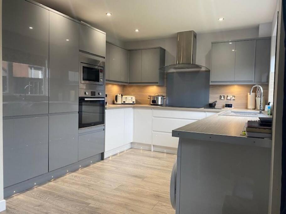 eine Küche mit Küchengeräten aus Edelstahl und weißen Schränken in der Unterkunft Tidy 3 bedroom property within St Andrews. in Fife