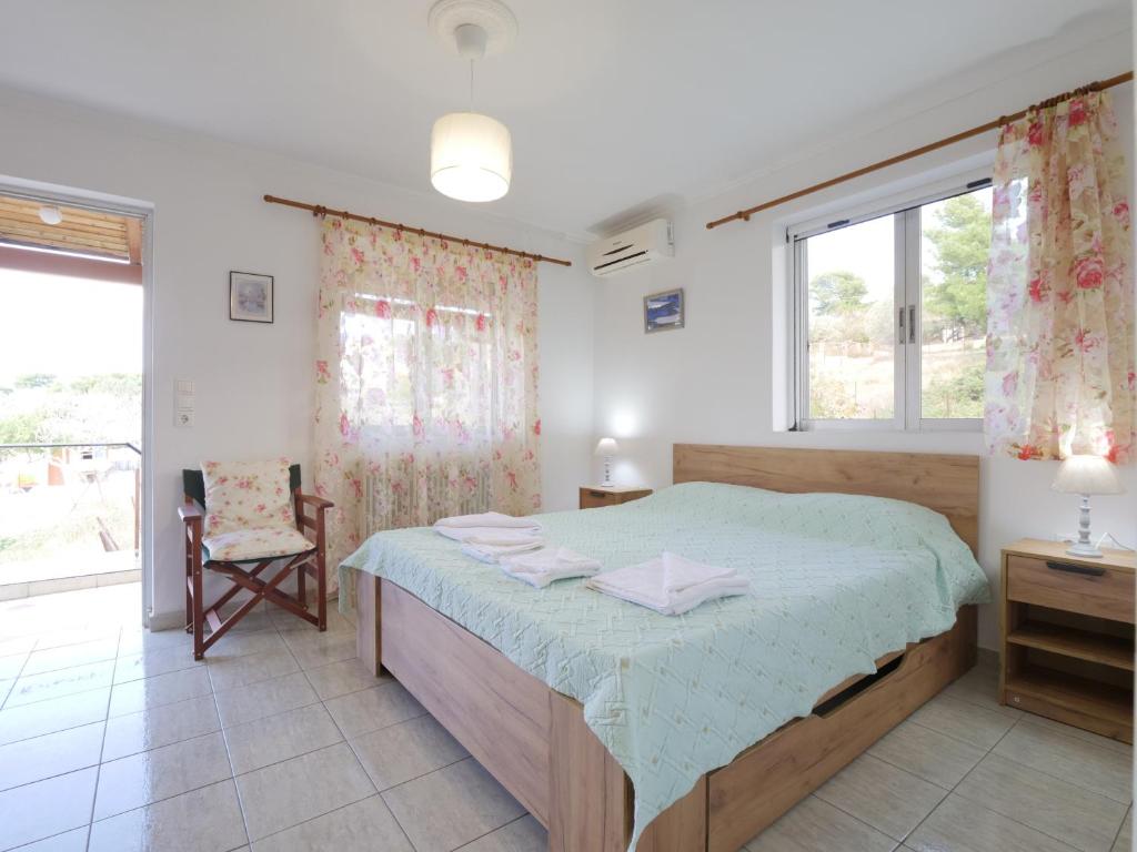 - une chambre avec un lit, une chaise et une fenêtre dans l'établissement GM country house, à Pórto Ráfti