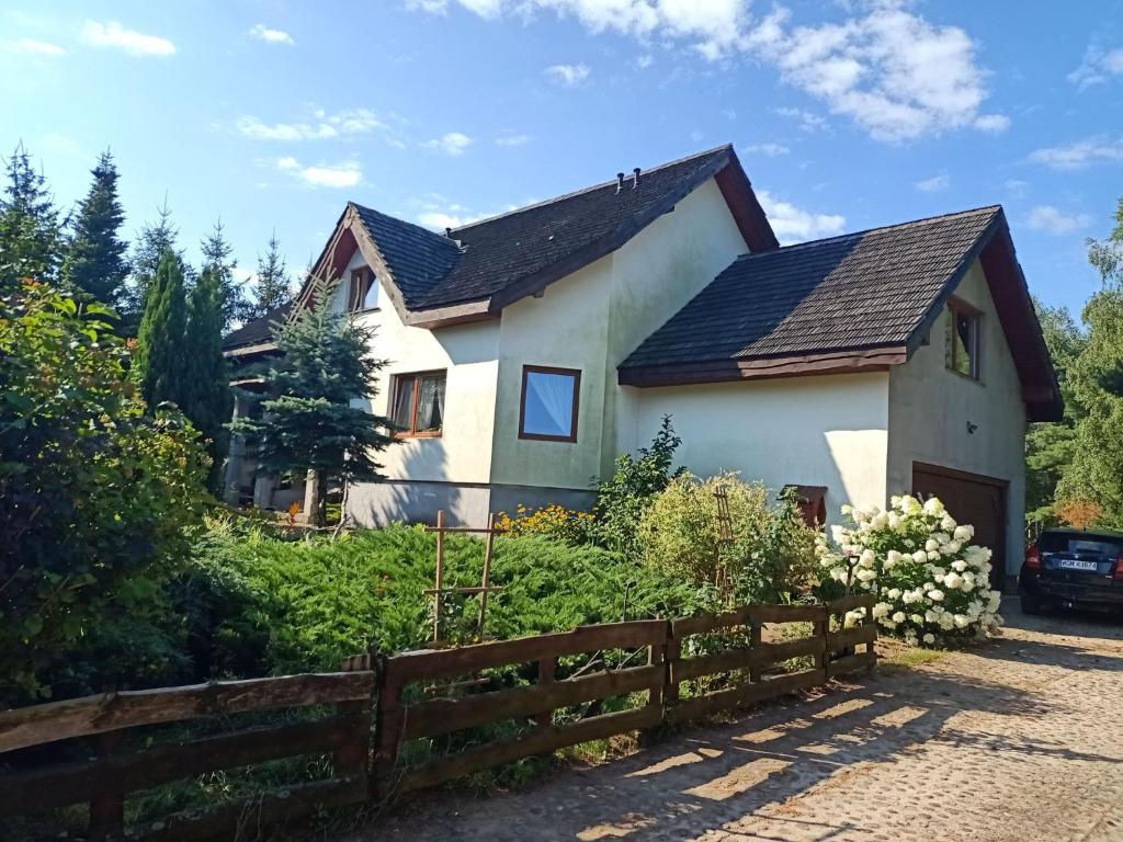 uma casa branca com uma cerca de madeira em Noclegi u Janusza em Zalesie
