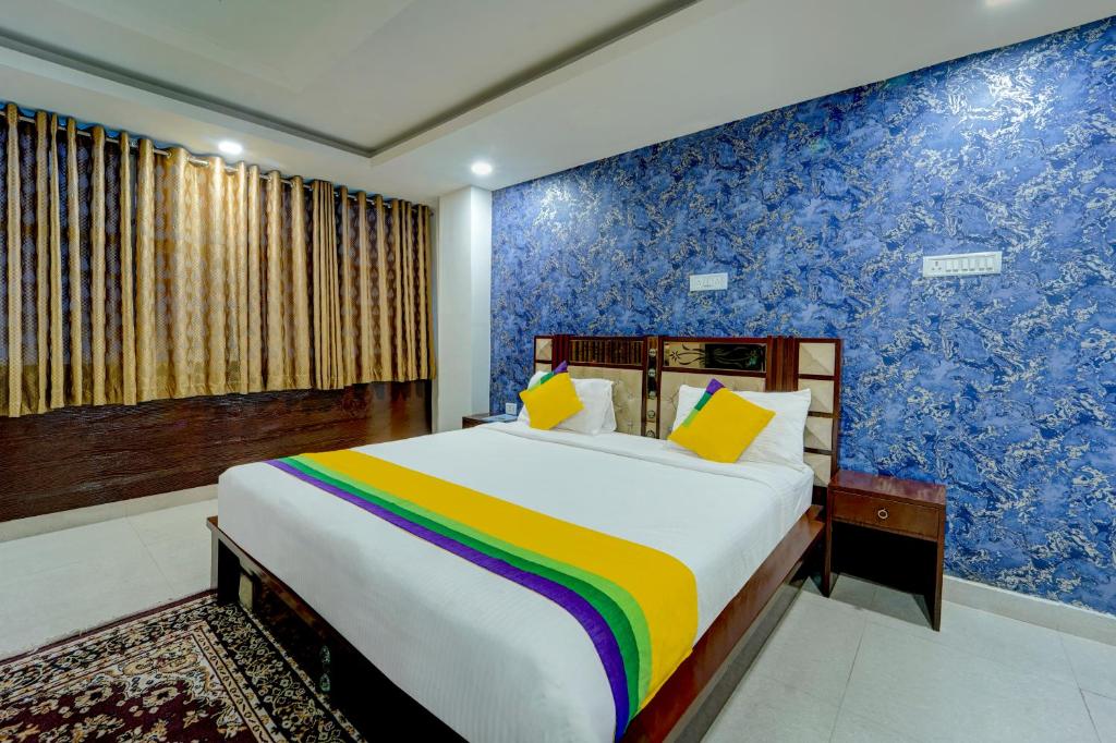 a bedroom with a large bed with a colorful wall at Itsy By Treebo - Buddha Inn in Patna