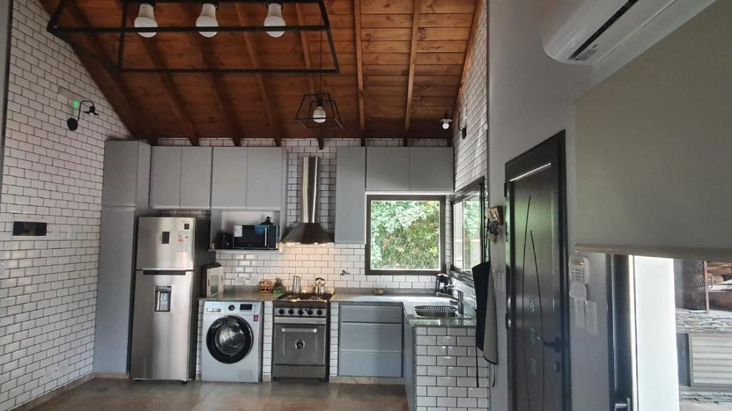 eine Küche mit Herd, Kühlschrank und Spüle in der Unterkunft Cabañas LOS BEDUINOS in Mar de las Pampas