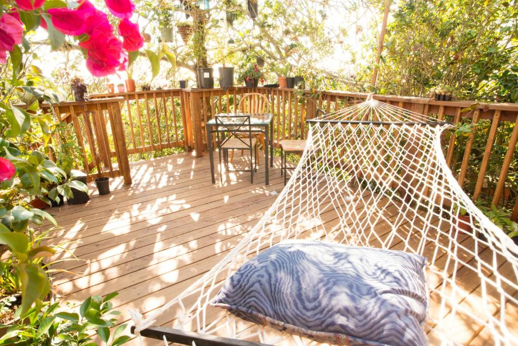 een hangmat op een terras met een tafel en bloemen bij Magical Bay View in Oakland Hills in Oakland