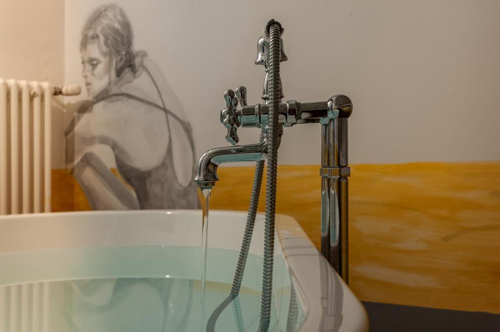 a bath tub with a water faucet in a bathroom at TAG Guest House in Viterbo