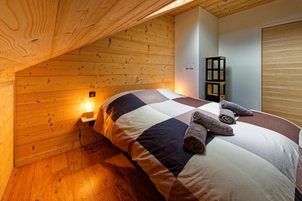 a bedroom with a bed in a room with wooden walls at Les balcons de Cuttura 2 & SPA chez Ô JurassiK in Cuttura
