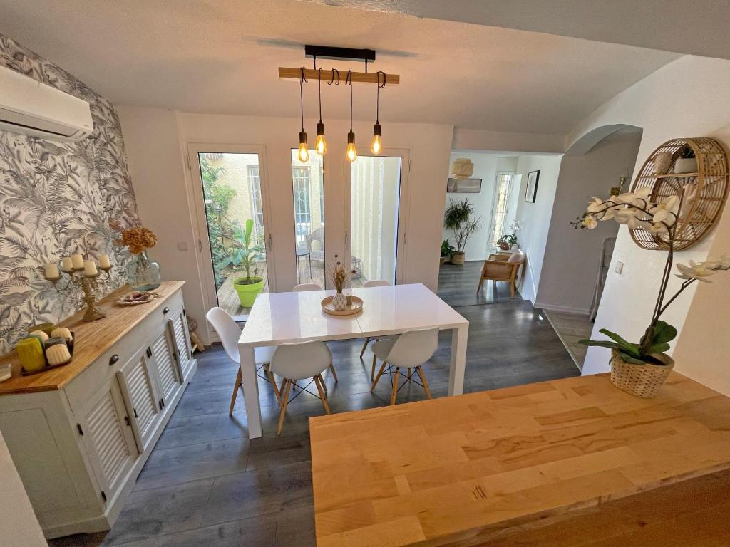 cocina y comedor con mesa blanca y sillas en Villa d&#39;architecte avec piscine et grand jardin, en Marsella