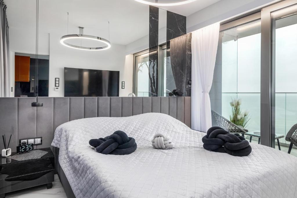 sypialnia z białym łóżkiem i ręcznikami na nim w obiekcie Holiday Exclusive w Rewalu