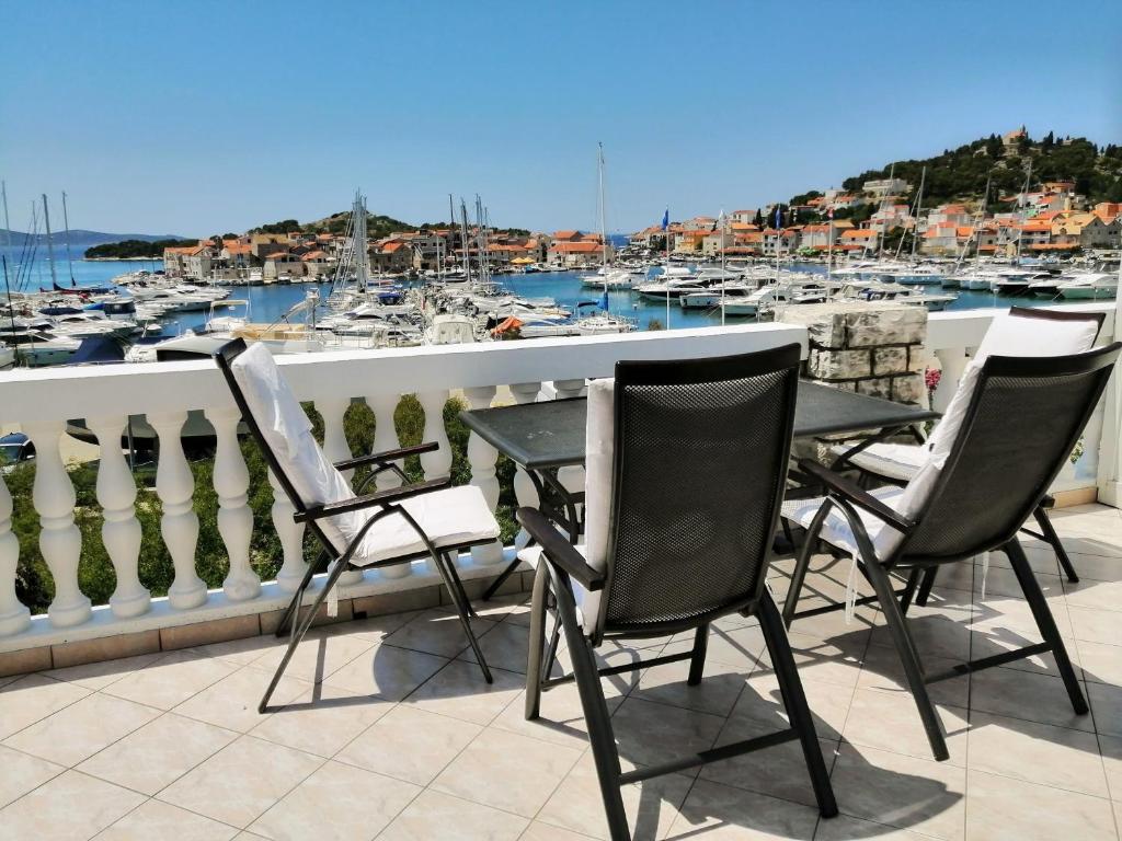 a table and chairs on a balcony with a marina at Apartments Tiho&Marija in Tribunj
