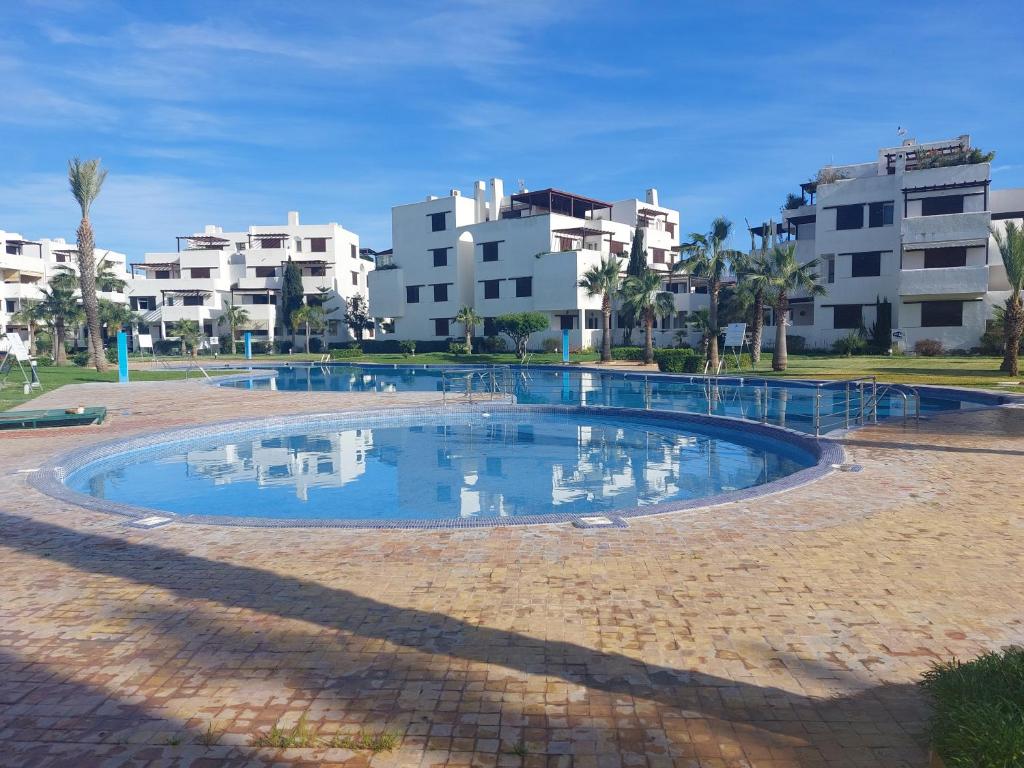 uma grande piscina com edifícios ao fundo em la Cassia Cabo Appartement em Cabo Negro