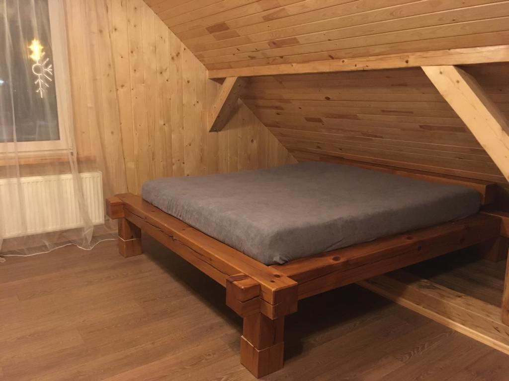 een bed in een houten hut bij Saules Rats Apartamenti in Madona