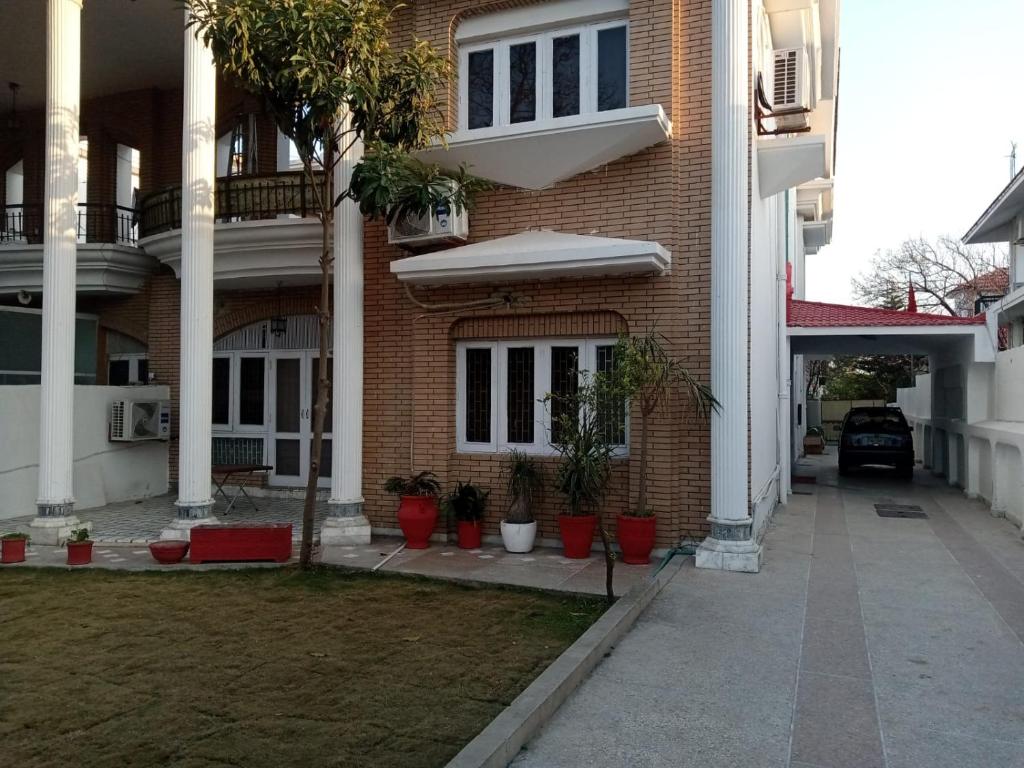 a brick house with potted plants in front of it at heritage inn guest House Islamabad.F10/1 in Rawalpindi
