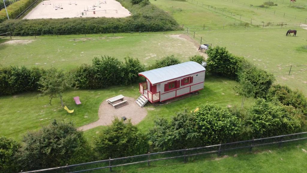 uma vista aérea de uma pequena casa num campo em La Roulotte des Matis em Cheux