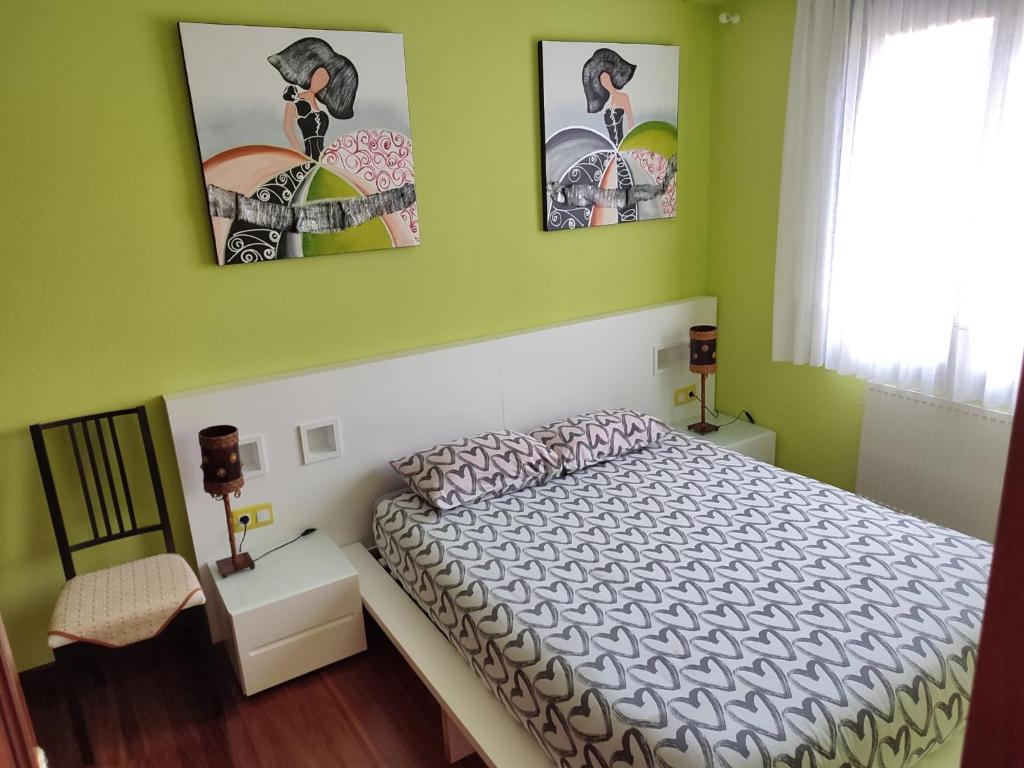 una camera con un letto e due quadri appesi al muro di Apartamento con piscinas a Castro-Urdiales