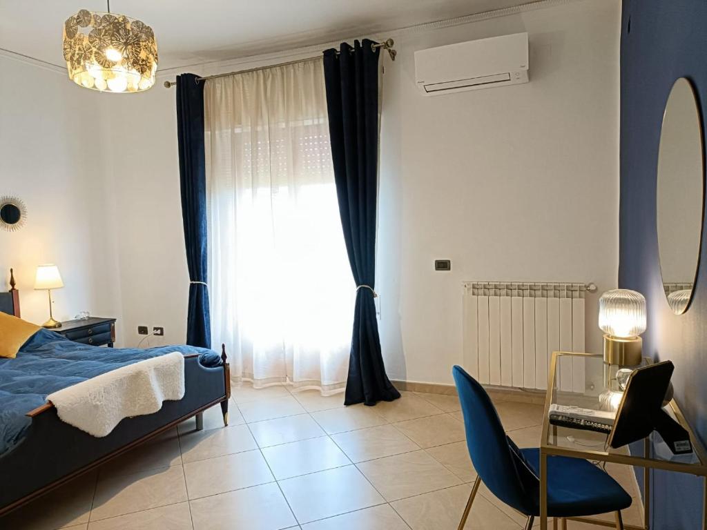 um quarto com uma cama, uma mesa e uma cadeira em B&B Margherita em Bagheria