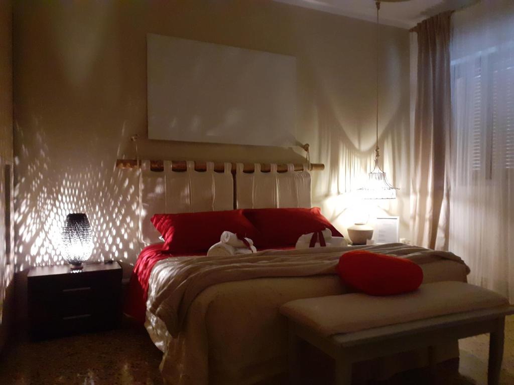 チェーリエ・メッサーピカにあるAlloggio turistico "home isabella"のベッドルーム1室(大型ベッド1台、赤い枕付)