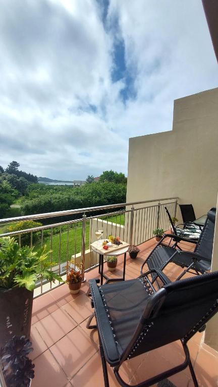 a patio with chairs and a table on a balcony at I 6 Goose Valley! Golf and more in Plettenberg Bay