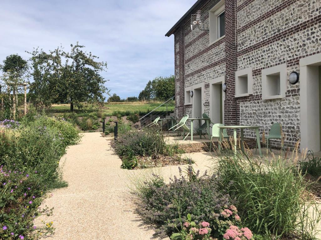 a brick house with a patio and flowers in front of it at Les Sept Logias in Les Loges