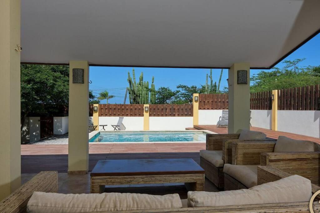 a living room with a swimming pool and a patio at Private Peaceful Paradise on One Happy Island in Oranjestad