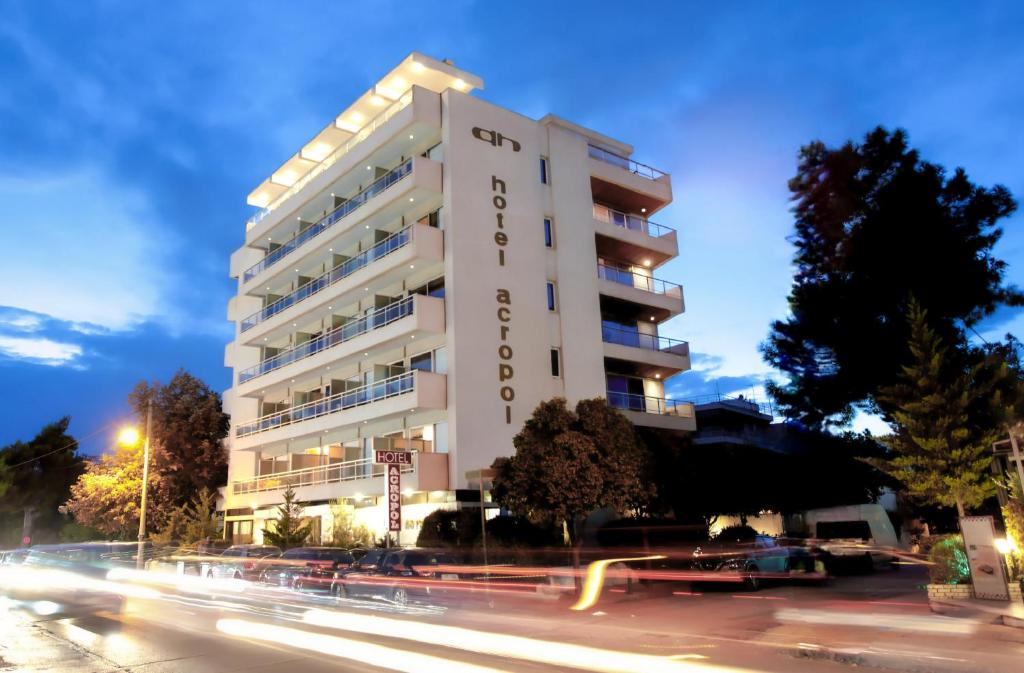 um edifício branco alto com uma rua em frente em Acropol Hotel em Atenas