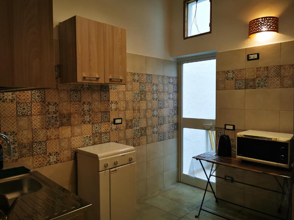 een kleine keuken met een wastafel en een raam bij LA VECCHIA TORRE 1920 in Grottaglie