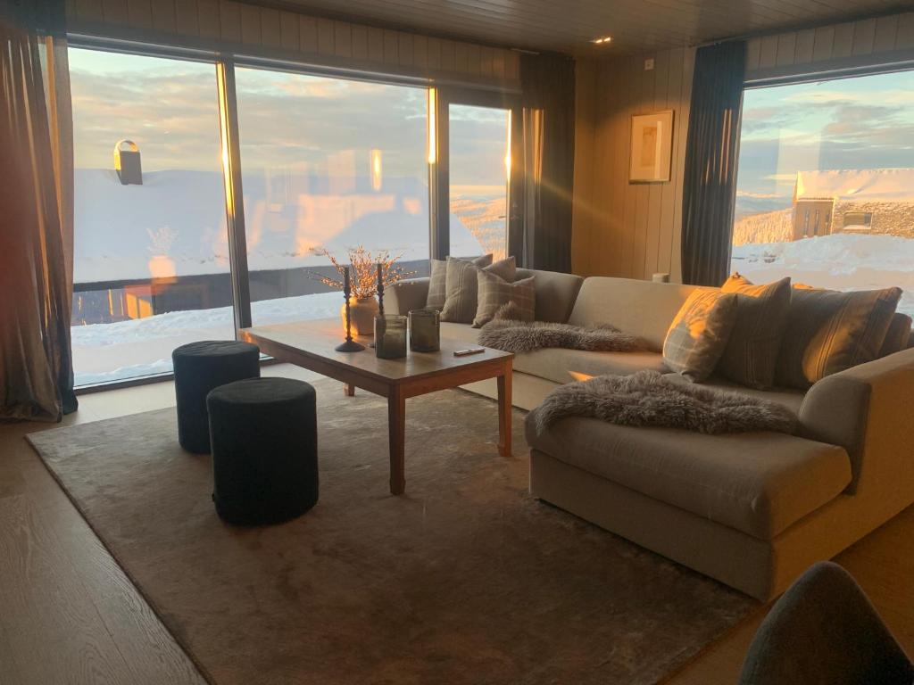 ein Wohnzimmer mit einem Sofa und einem Tisch in der Unterkunft Appartment Norefjell ski in/ski out in Noresund