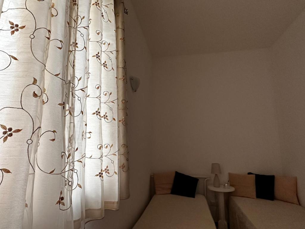 mały pokój z łóżkiem i zasłoną w obiekcie La Petraia w mieście Magliano