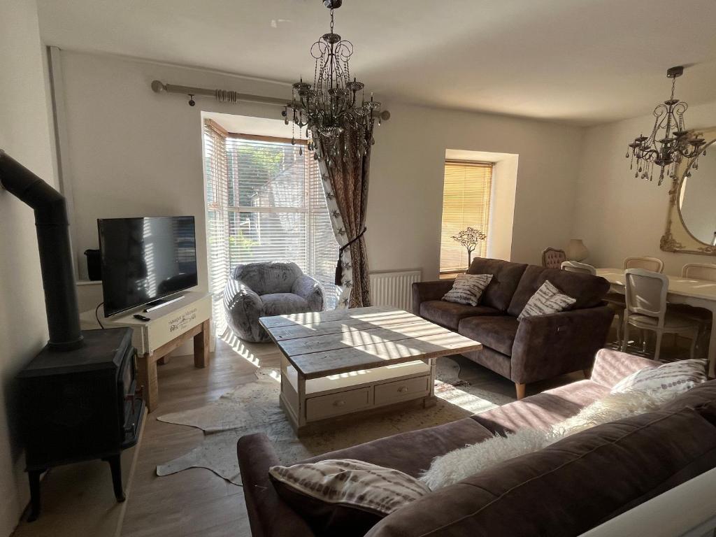 uma sala de estar com um sofá e uma mesa em Matlock Maisonette em Matlock