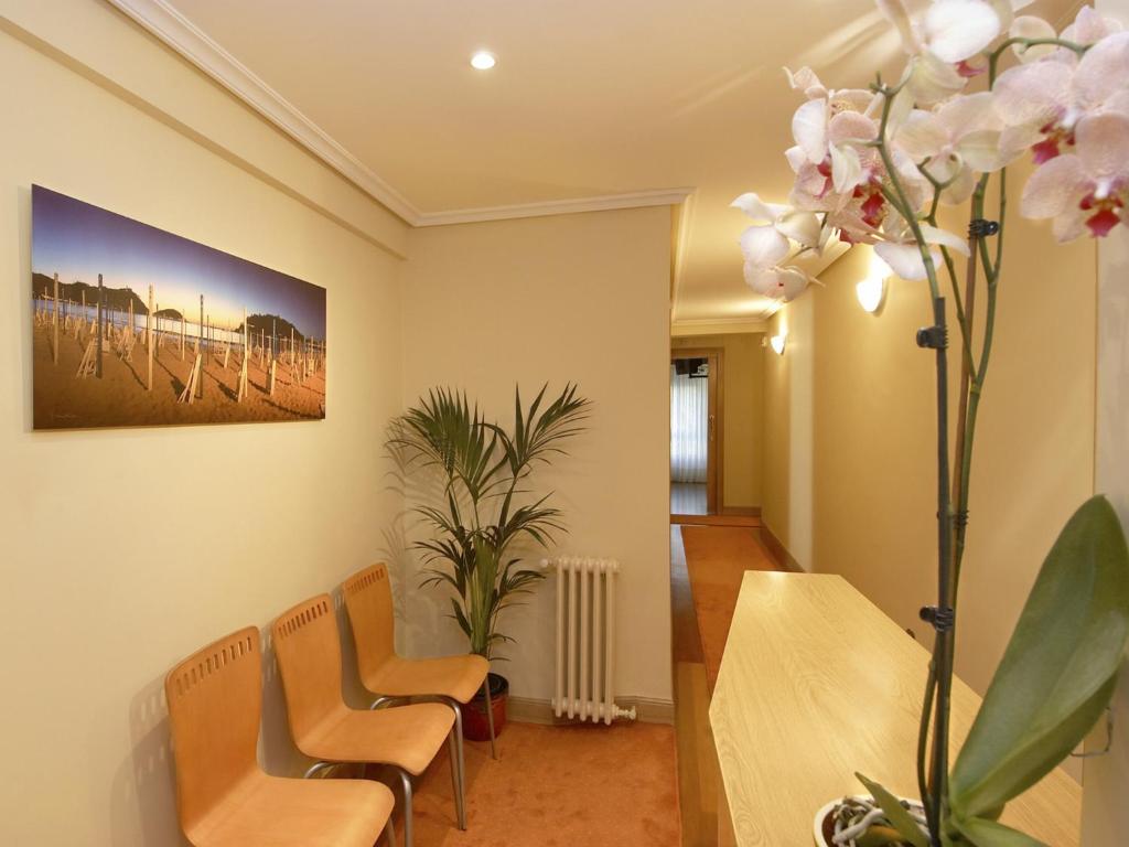 a living room filled with furniture and flowers at Pension Anoeta in San Sebastián