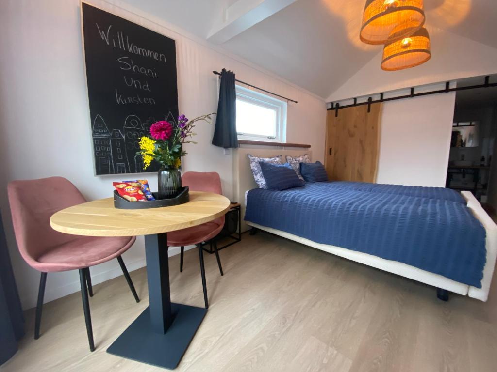- une petite chambre avec un lit et une table avec un lit bleu dans l'établissement Style Gardenhouse Zwanenburg near AMSTERDAM, HAARLEM, ZANDVOORT, à Zwanenburg
