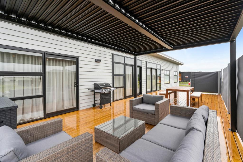 an outdoor living room with a couch and chairs at Pride of Pinot - Martinborough Holiday Home in Martinborough 